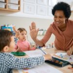 Happy,African,American,Teacher,And,Small,Boy,Giving,High-five,During
