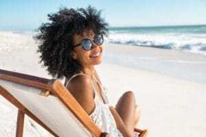 Portrait,Of,Happy,Young,Black,Woman,Relaxing,On,Wooden,Deck