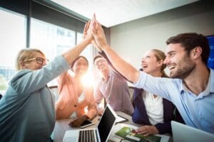 Business,People,Giving,High,Five,At,Desk,In,The,Office
