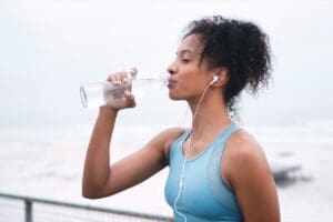 Woman,,Drinking,Water,And,Exercise,In,Outdoor,For,Hydration,,Music