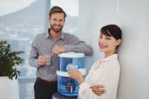 Portrait,Of,Smiling,Executives,Holding,Glasses,Of,Water,In,Office