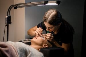 Professional,Woman,Beautician,Makes,Eyelash,Extension,For,Female,Client,In
