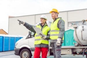 Workers,In,Mobile,Toilet,Rental,Service,Standing,In,Front,Of