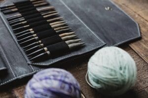 Locally Handmade knitting needles and yarn on a wooden table
