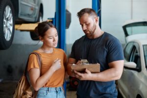 Woman,,Mechanic,And,Sign,Quote,In,Auto,Repair,Shop,,Invoice