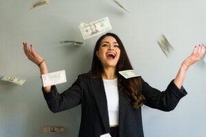 Excited,Businesswoman,Throwing,Money,In,The,Air,,Celebrating,Financial,Success