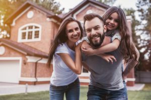 Happy,Family,Is,Standing,Near,Their,Modern,House,,Smiling,And